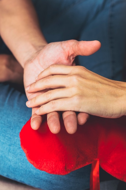 Free Photo couple holding hands on toy heart 