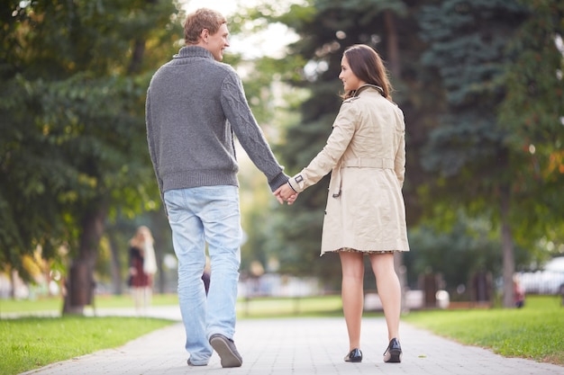 Couple holding hands walking away