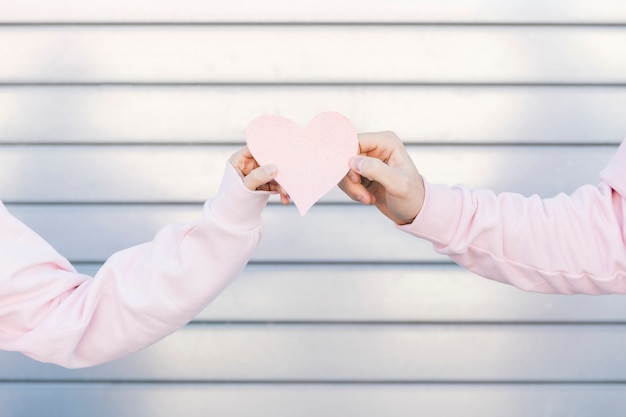 Free photo couple holding paper decorative symbol of heart