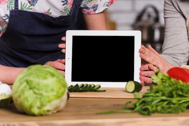 Free Photo couple holding tablet with screen to camera