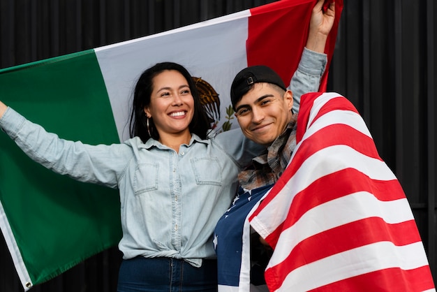 Free photo couple holding usa and mexico flags