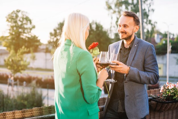 Couple holding wine glasses kissing each other at outdoors