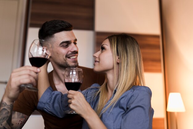 Free photo couple holding wine glasses looking at each other