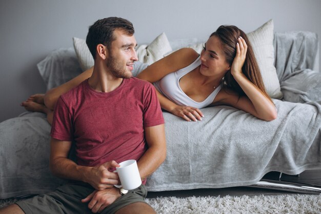 Couple at home together sitting on floor by the couch