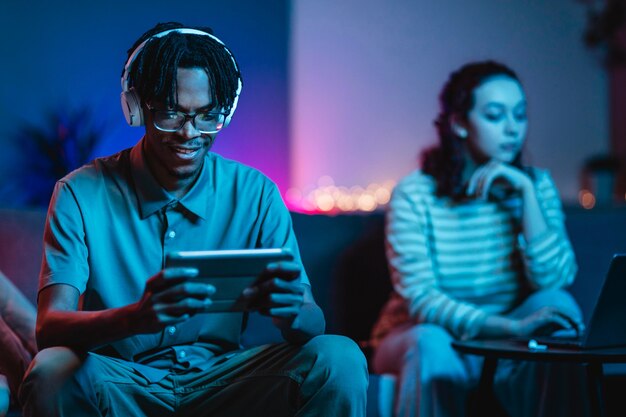 Couple at home together with tablet and headphones