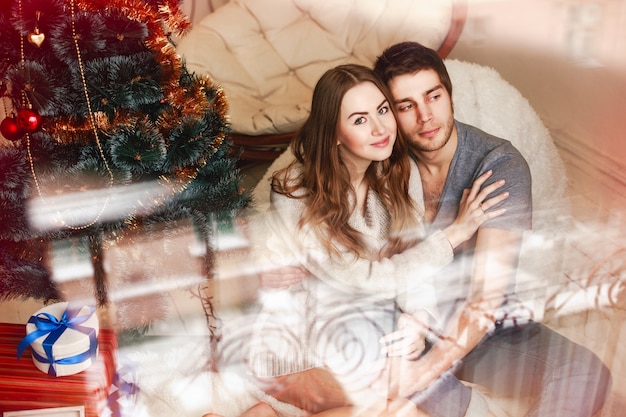 Couple hugging next to the christmas gifts