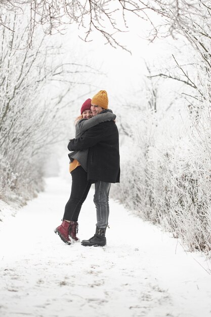 Couple hugging each other outdoors in winter