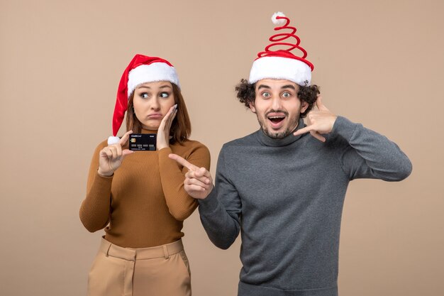 A couple is standing next to the Christmas tree