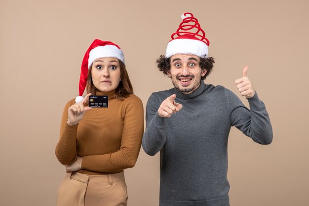 A couple is standing next to the Christmas tree