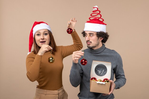 A couple is standing next to the Christmas tree