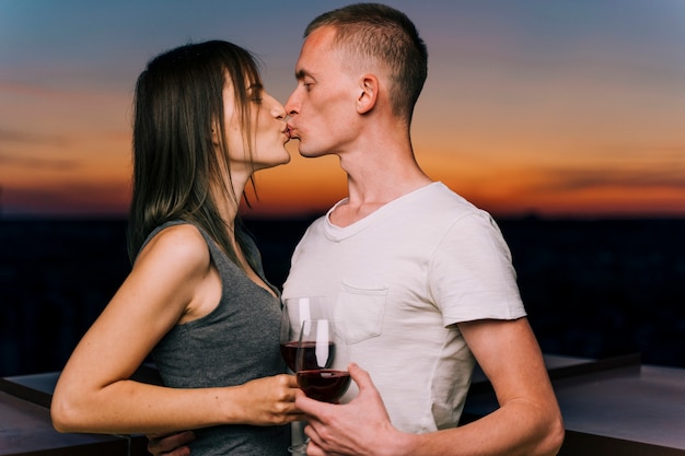 Couple kissing in the sunset on rooftop