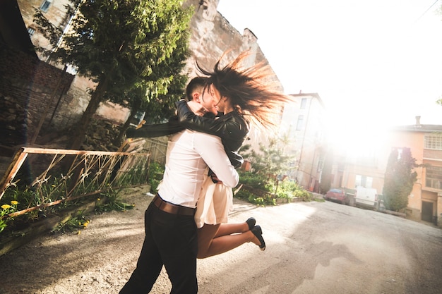 Free photo couple kissing while man lifts woman