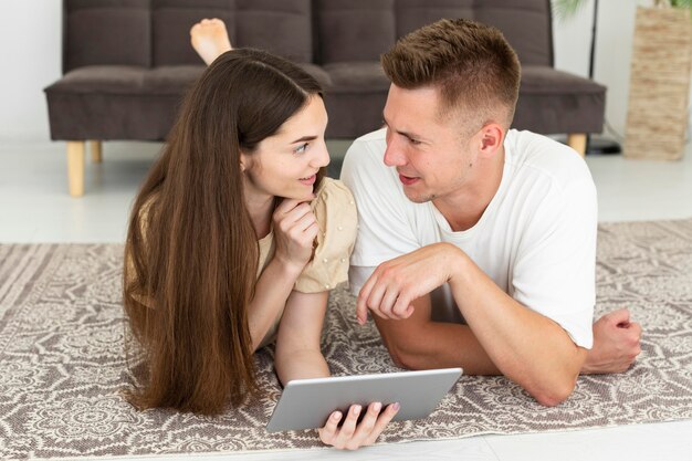 Couple laying on the floor while looking at each other