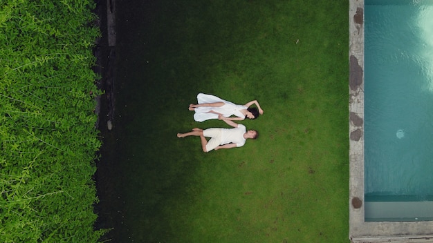 Free photo couple lie on a graas on a bali