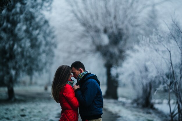 Couple looking closely at eyes with blurred snowy background