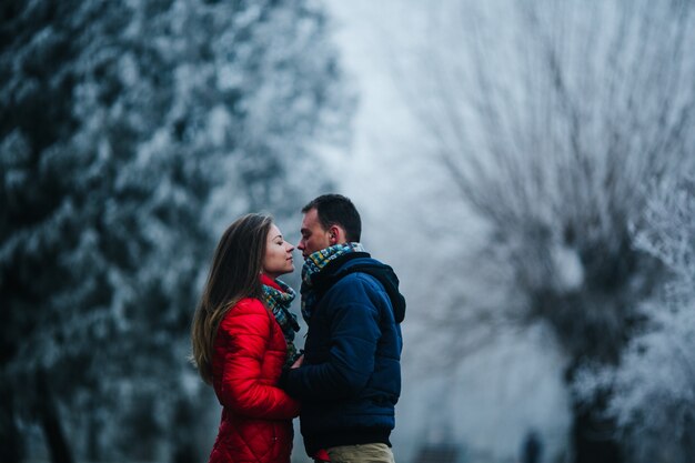 Couple looking closely at eyes with blurred snowy background