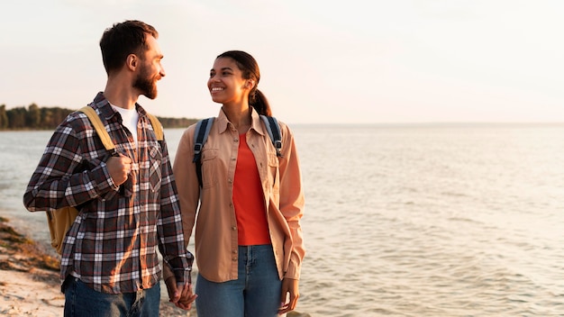 Couple looking at each other while taking a walk next to the sea