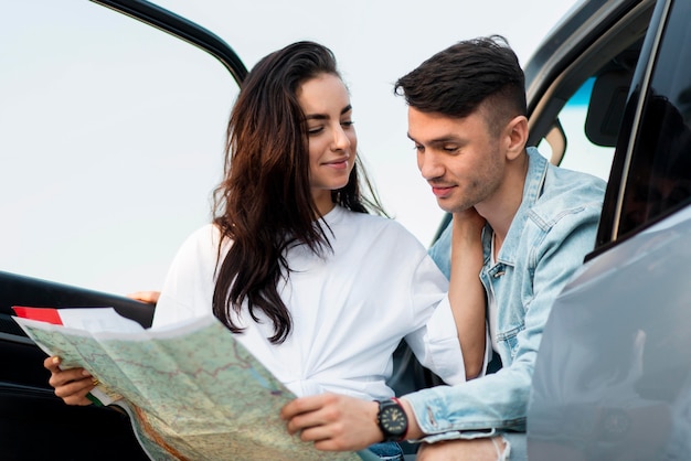 Couple looking on a map together medium shot