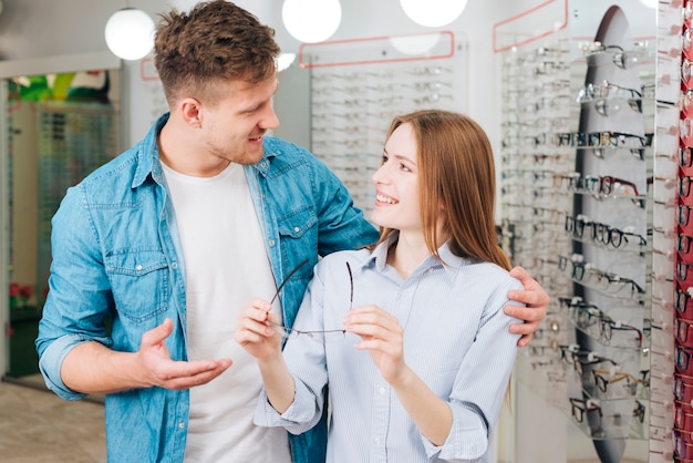 Couple looking for new glasses at optometrist