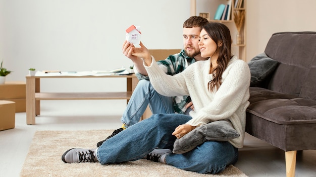 Couple looking at small house full shot