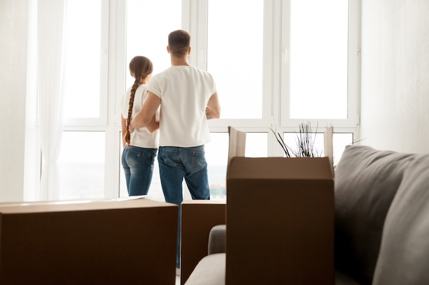 Free photo couple looking through window planning future in new home