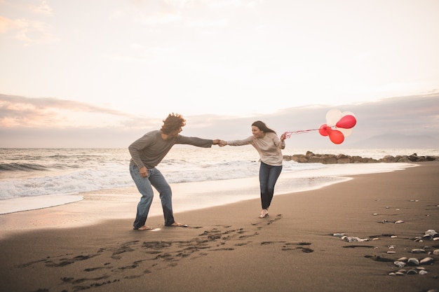 Free photo couple in love playing and she with balloons in hand