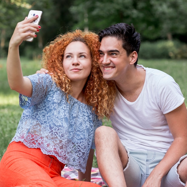 Free photo couple in love taking a selfie with mobile phone