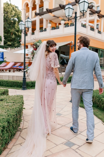 Couple  in love walking in luxury villa while celebrating  wedding . Full lenght.