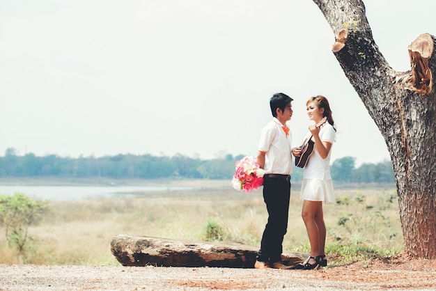 Couple in love with playing guitar at nature