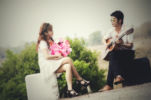 Free photo couple in love with playing guitar at nature