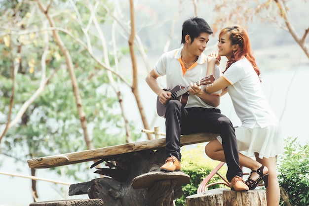 Couple in love with playing guitar at nature