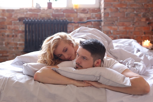 Free photo couple lying on the bed and chatting