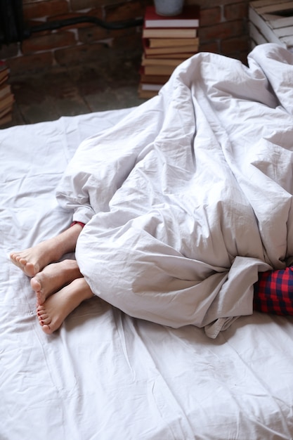 Couple lying on the bed in twin pijamas, feet view