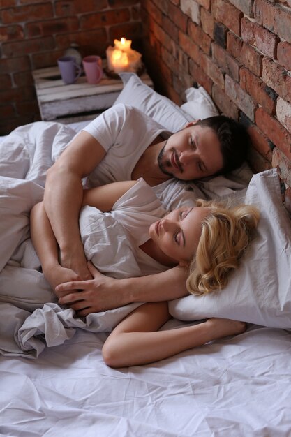 Couple lying on the bed in twin pijamas and sleeping