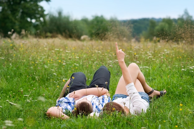 Free photo couple lying down in the meadow