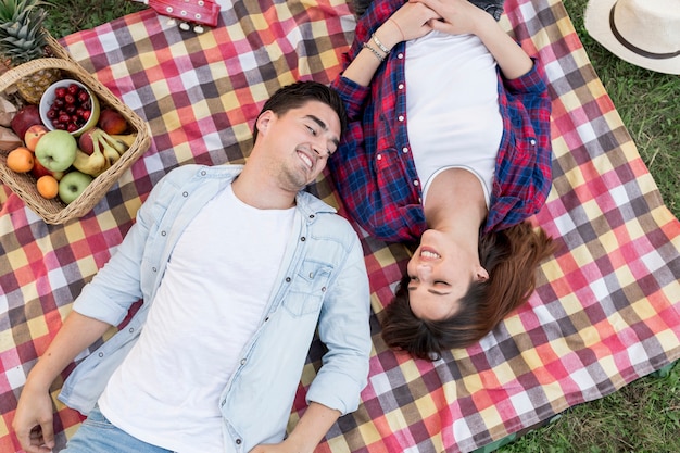 Couple lying on a picnic blanket top view