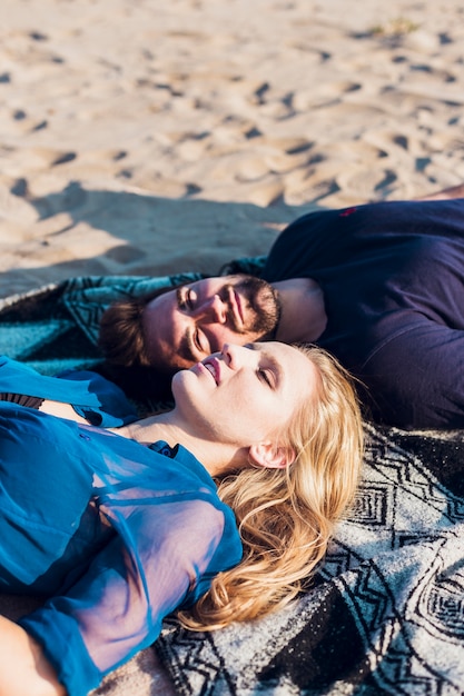 Free photo couple lying on sand