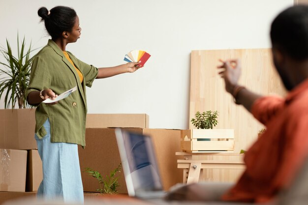 Couple making plans together for renovating home using laptop and color palette