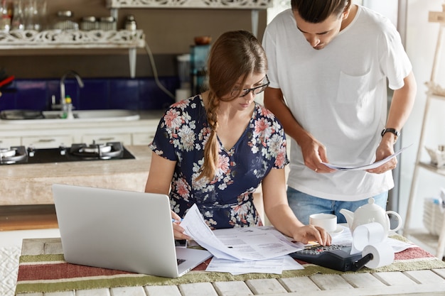 Free Photo couple managing budget together in kitchen