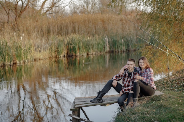 Free Photo couple near river in a fishing morning