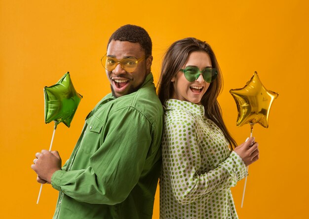 Couple at party having fun and holding balloons