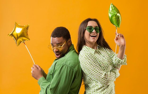 Free photo couple at party having fun and holding balloons