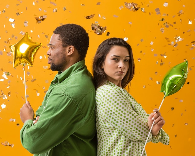 Free photo couple at party having fun and holding balloons