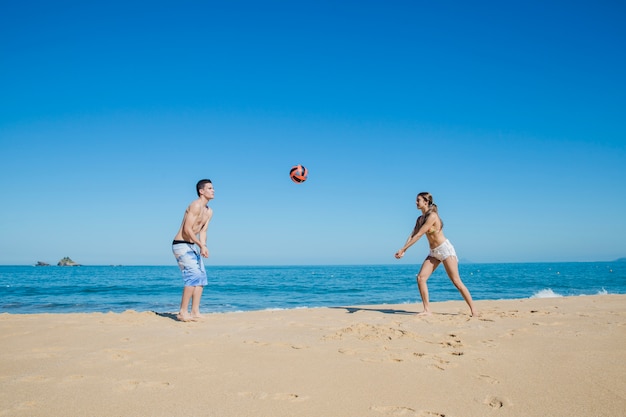 Free Photo couple playing ball at the beach