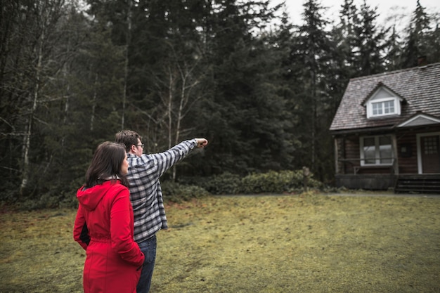 Free photo couple pointing at cabin