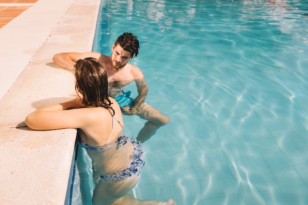 Couple in pool talking