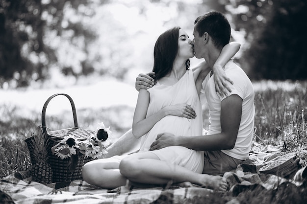 Couple pregnant, having picnic in park