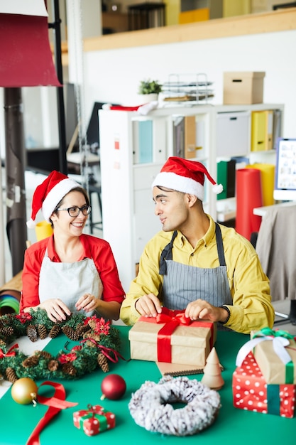 Free photo couple preparing christmas decoration and wrapping gifts