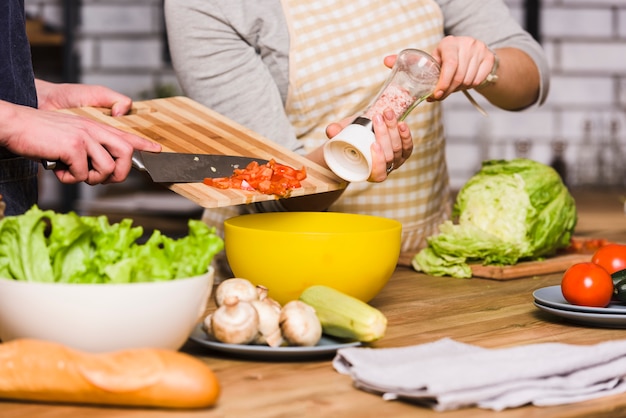 Free photo couple preparing vegetable salad