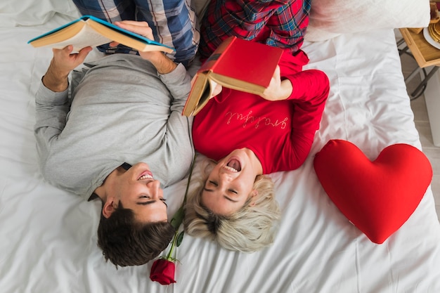 Free photo couple reading in bed on valentines day